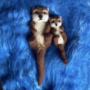 Gefilzte Otter-Figuren, Mutter und Jungtier auf blauem Untergrund