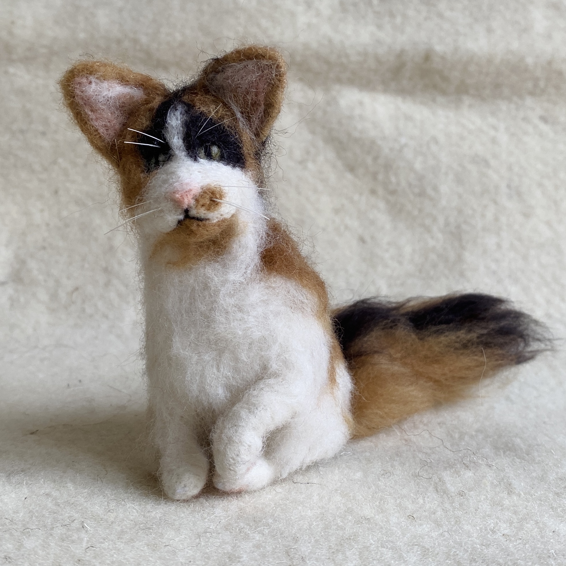 Handgefilzte dreifarbige Katze mit buschigem Schwanz