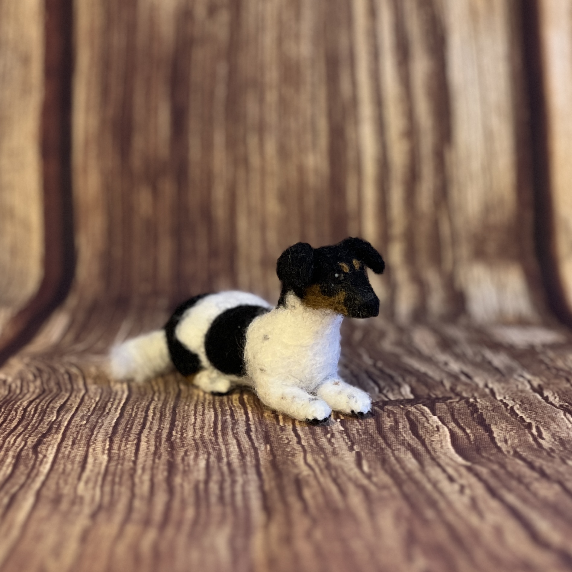 Handgefilzter Hund schwarz-weiss liegend – Unikat aus Filzwolle