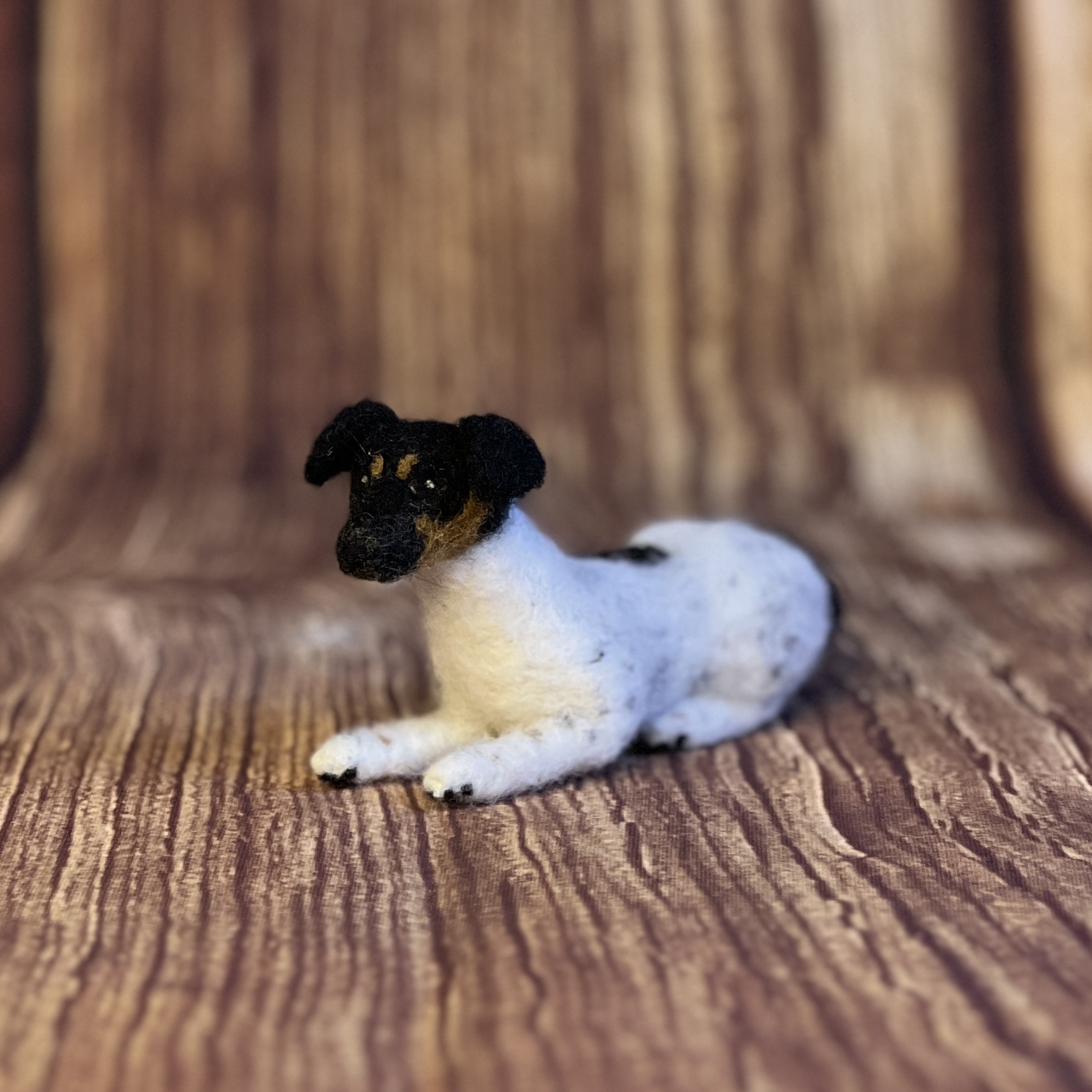 Handgefilzter Hund schwarz-weiss liegend – Unikat aus Filzwolle